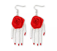 Brincos de rosa com mãos de esqueleto